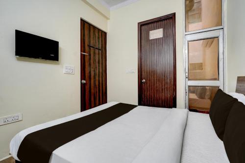a small bedroom with a bed and a television at Hotel O Railway Station Road Formerly Alwar Delight in Alwar