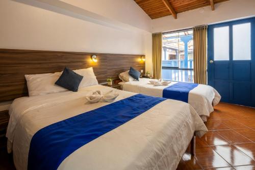 a hotel room with two beds and a window at SAN BLAS PLAZA INn in Cusco
