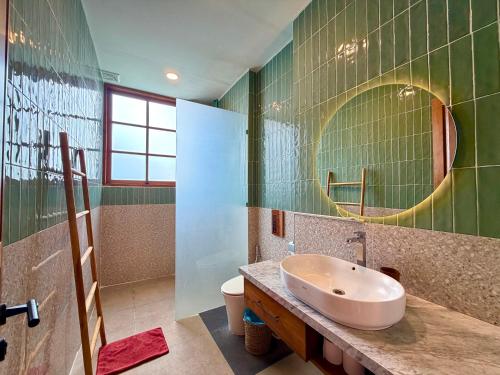 a bathroom with a sink and a mirror at Twinseas Villa in Uluwatu