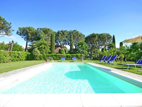 コルトーナにあるBelvilla by OYO Balmy Villa in Cortona with Poolの青いラウンジチェアとスイミングプールを併設しています。