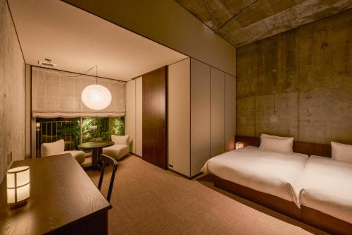 a bedroom with a bed and a table and a chair at KÚON Hakone Gora in Hakone