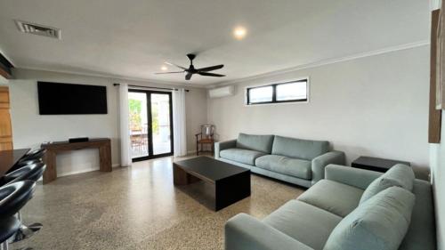 a living room with a couch and a tv at Beachside Bliss In The Crown in Kawana Waters
