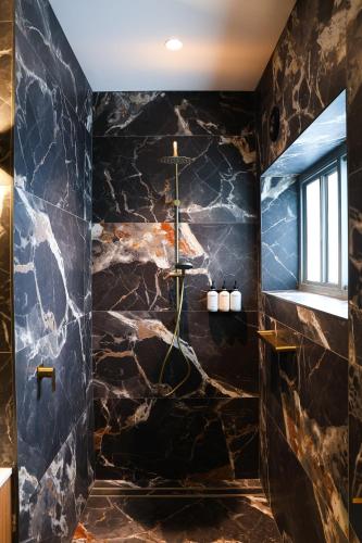 a bathroom with a black stone wall at Hotel Gosford in Gosford