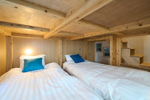 two beds in a room with wooden ceilings at DreamFriend新浦安 in Tokyo