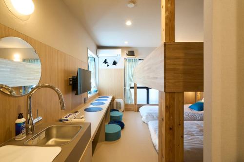 a bathroom with a sink and a bed in a room at DreamFriend新浦安 in Tokyo