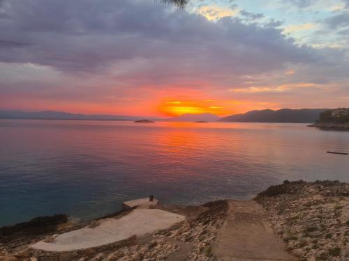a sunset over a body of water with the sun setting at Vila Elena in Prigradica