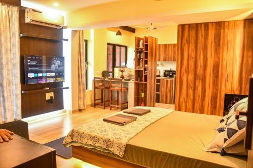 a bedroom with a large bed and a kitchen at UnigoOne Apartments, BH, Palolem in Canacona