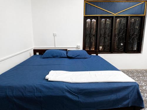 a blue bed in a room with a window at A to Z surf camp in Arugam Bay