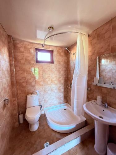 a bathroom with a toilet and a tub and a sink at Wey Stop in K'vemo Alvani
