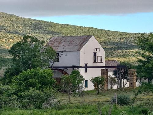 an old white house in the middle of a field at Glen Avon Farm in Somerset East