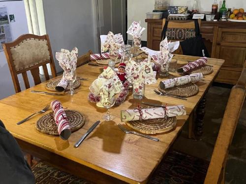 a wooden table with plates and wine glasses on it at Glen Avon Farm in Somerset East