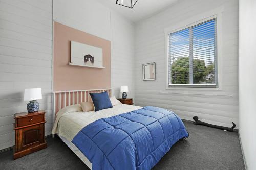 a bedroom with a bed and a window at The Old Guide Hall in Allansford