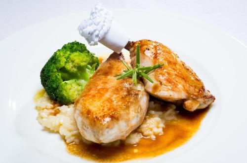 a plate of food with chicken rice and broccoli at Der Erlhof Restaurant & Landhotel in Zell am See