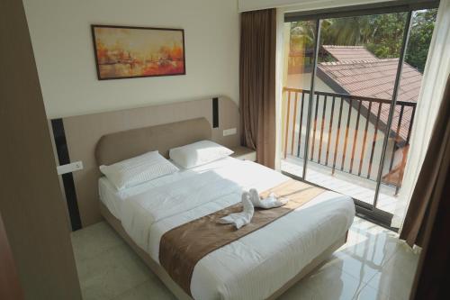 a bedroom with a bed and a large window at Ezzora Stays in Kozhikode