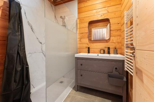 a bathroom with a sink and a mirror at Les chalets Super Geants in Saint-François-Longchamp