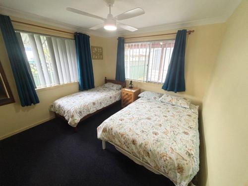 a bedroom with two beds and a ceiling fan at Wenlaw Cottage Rear Hat Head - Bring your own linen. in Hat Head