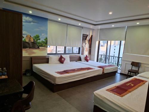 a bedroom with two beds and a balcony at Melanta Hotel - FLC Sầm Sơn in Sầm Sơn