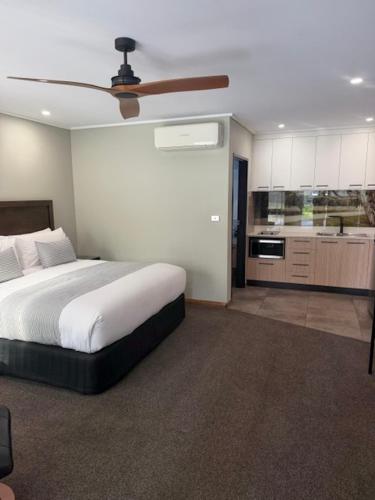 a bedroom with a bed and a ceiling fan at Barooga River Gums Motor Inn in Barooga