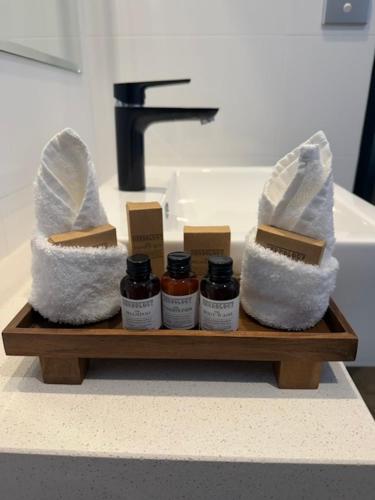 a bathroom sink with a shelf with four bottles of honey at Barooga River Gums Motor Inn in Barooga