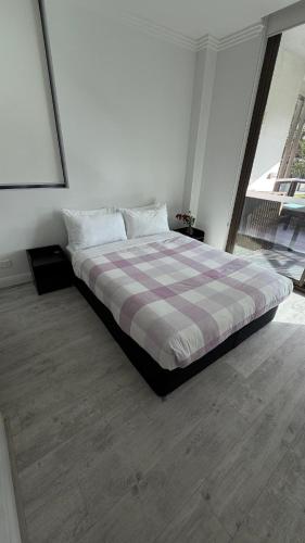a bedroom with a bed with a checkered blanket at Olympicpark 12 Free Parking in Sydney