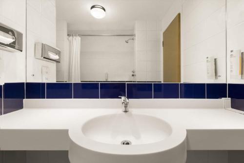 a bathroom with a white sink and a mirror at Days Inn Hotel Leicester in Leicester