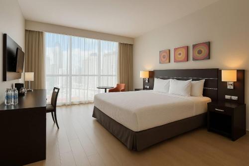 a hotel room with a bed and a desk and a bed and a window at Tryp by Wyndham Panama Centro in Panama City