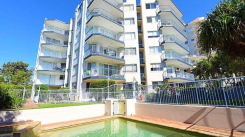 an apartment building with a pool in front of a building at Outlook Unit 7 in Kawana Waters