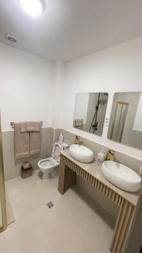 a bathroom with two sinks and a toilet at SunVillaTuzi in Tuzi