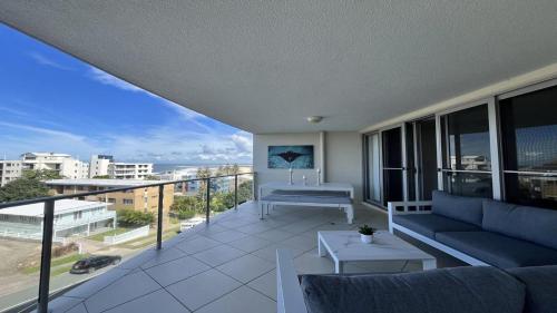 a balcony with a couch and a view of the ocean at Seabourn Unit 502 in Caloundra