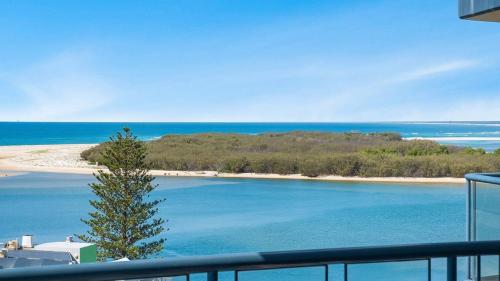 a view of a beach and the ocean from a balcony at Grand Pacific Unit 104 in Caloundra