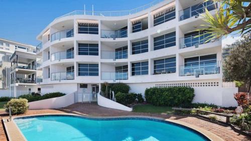 an apartment building with a swimming pool in front of it at Pumicestone Chase Unit 5 in Caloundra