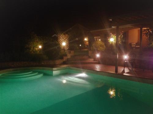a swimming pool at night with lights at B&B Sedici Pini in Pomezia