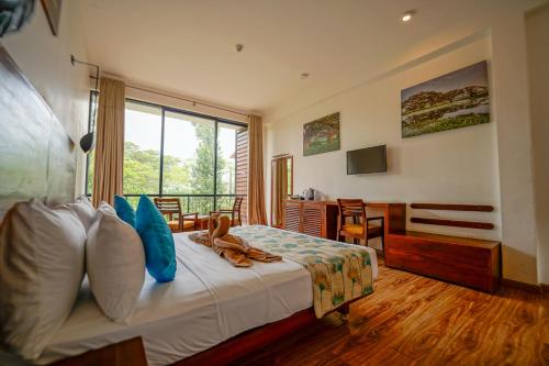 a hotel room with a bed and a window at Rain Tree by Oak Ray in Tissamaharama
