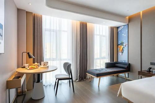 a hotel room with a bed and a table and a bed and a desk at Atour Hotel Altay in Altay