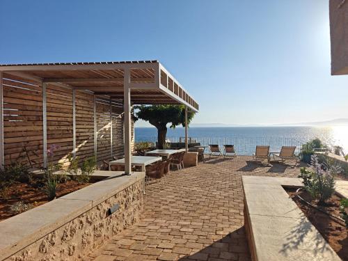 a patio with a table and chairs and the ocean at Dimitra's Studios in Stoupa