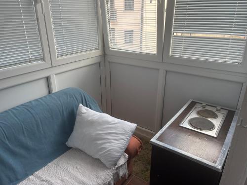 a room with a couch and a pillow and windows at Room with balcony Milan in Herceg-Novi