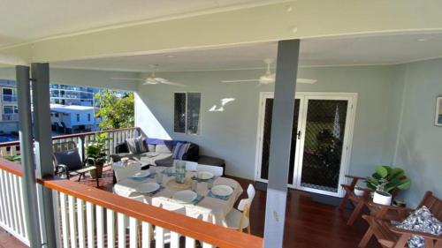a room with a balcony with a table and chairs at Blue Beach House in Caloundra