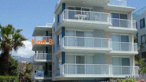 a tall building with white balconies and an orange sign on it at Spinnaker Seas Unit 8 in Caloundra