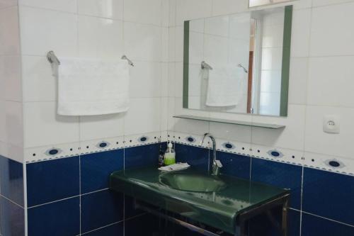 a bathroom with a green sink and a mirror at Nomad Guest House Osh in Osh