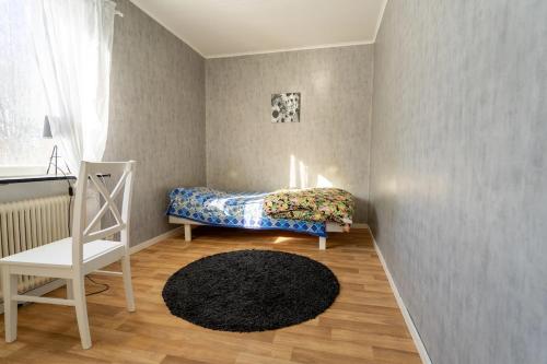 a small bedroom with a bed and a chair at Private Villa with parking - Skellefteå in Skellefteå