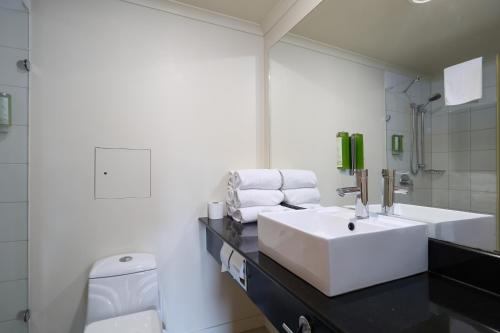 a white bathroom with a sink and a toilet at Saxton Lodge in Nelson