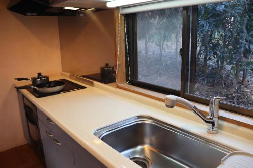a kitchen with a sink and a window at The Villa Kotoshiro -ヴィラ コトシロ- in Matsue