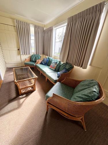 a living room with two couches and a table at Bundi Hat Head - Bring your own linen in Hat Head