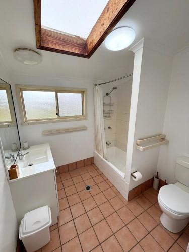 a bathroom with a toilet sink and a shower at Bundi Hat Head - Bring your own linen in Hat Head