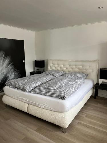 a white bed in a bedroom with a white wall at Hof Busen Farm Haus in Mönchengladbach