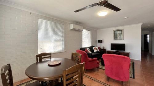 a living room with a table and red chairs at Drakes Hideaway in Golden Beach