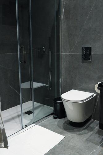 ein Badezimmer mit Toilette und Glasdusche in der Unterkunft Rois Constructions in Nikosia