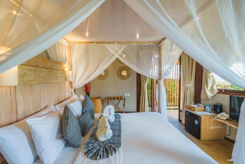 a bedroom with a white bed with a canopy at Ora Resort Avia Blue Lagoon in Nusa Lembongan