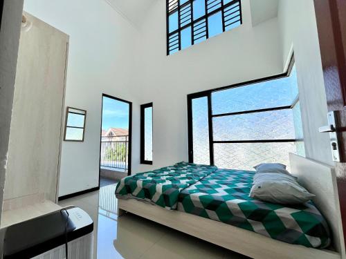 a bedroom with a bed and a large window at MP Villa Boulvard 43 Malang in Blimbing