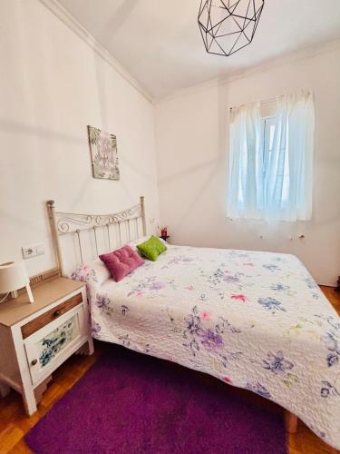 a bedroom with a bed and a purple rug at Apartamento en Monforte estación de tren in Monforte de Lemos